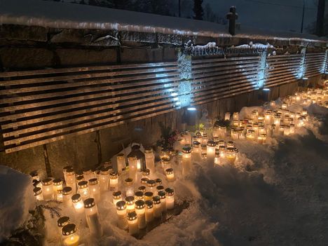 Hautausmaan kiviaitaa valaisivat sadat muistokynttilät.