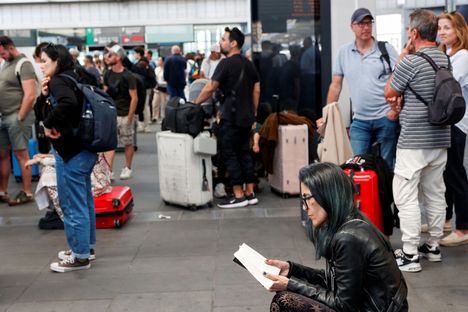 Ihmiset odottivat rautatieasemalla Espanjan Valenciassa sen jälkeen, kun massiivinen sähkökatko oli alkanut sekoittaa junaliikennettä.