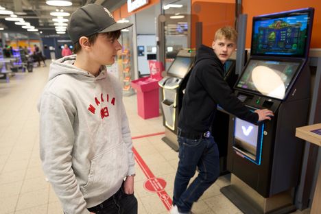 Tommi Viitavaara, 17, is obediently followed by a floor sticker outside the K-18 area when his friend Santeri Bäckman, 18, seeks the riches of the game machine.