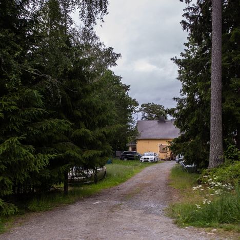 Kapea hiekkatie kulkee läpi hiljaisten metsä- ja peltomaisemien. Tiestä irtaantuu pihatie, joka vie keltaisen talon pihaan. Talon ikkunat on naulattu vanerilla umpeen. Vuodenvaihteessa poliisi kiinnostui talosta ja ihmisistä, jotka siellä oleilivat.