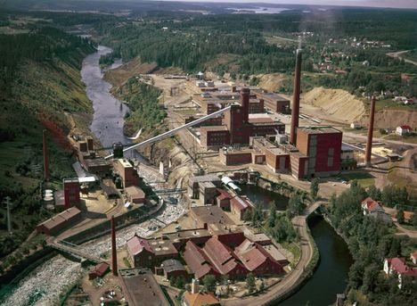 Paperitehdas kuvattiin yläilmoista vuonna 1969. Etualalla on Tehdassaaren rakennuksia. Happotorni ja purkuluvan saanut korkea keittämörakennus erottuvat kuvan keskellä.
