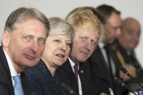 Kovan brexitin kannattajat toivovat potkuja valtiovarainministeri Philip Hammondille (vas.). Hänen vierellään pääministeri Theresa May sekä brexit-leirin kärkihahmoihin kuuluva ulkoministeri Boris Johnson.