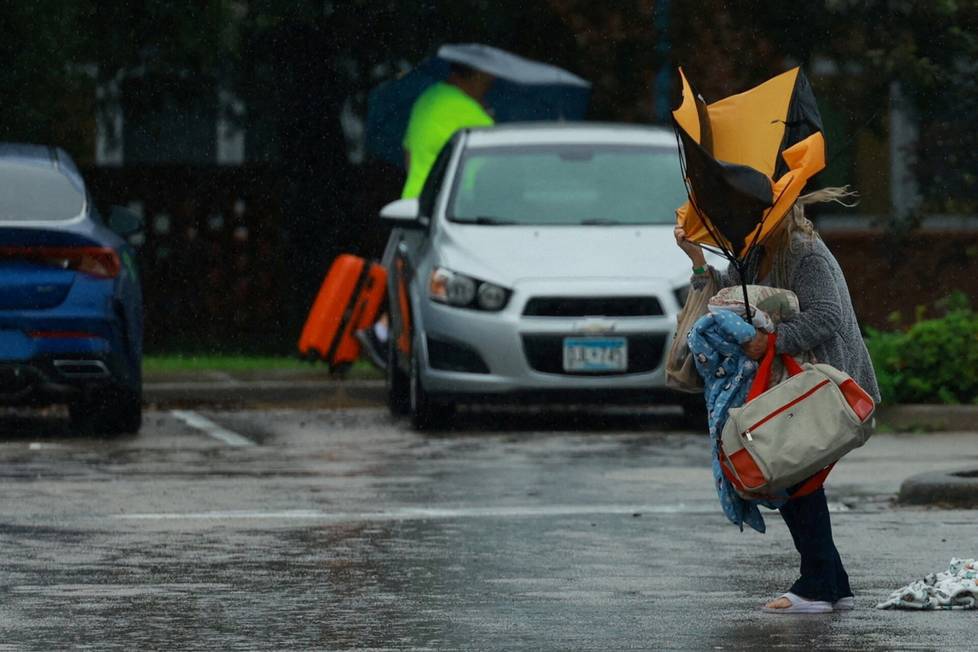 In Lakeland, a local woman sought shelter as Hurricane Milton approached Florida. A gust of wind threw the woman's umbrella around.