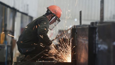 Kiinalainen työntekijä hitsasi teräselementtiä Hangzhoussa, itäisessä Zhejiangin maakunnassa heinäkuussa 2025.