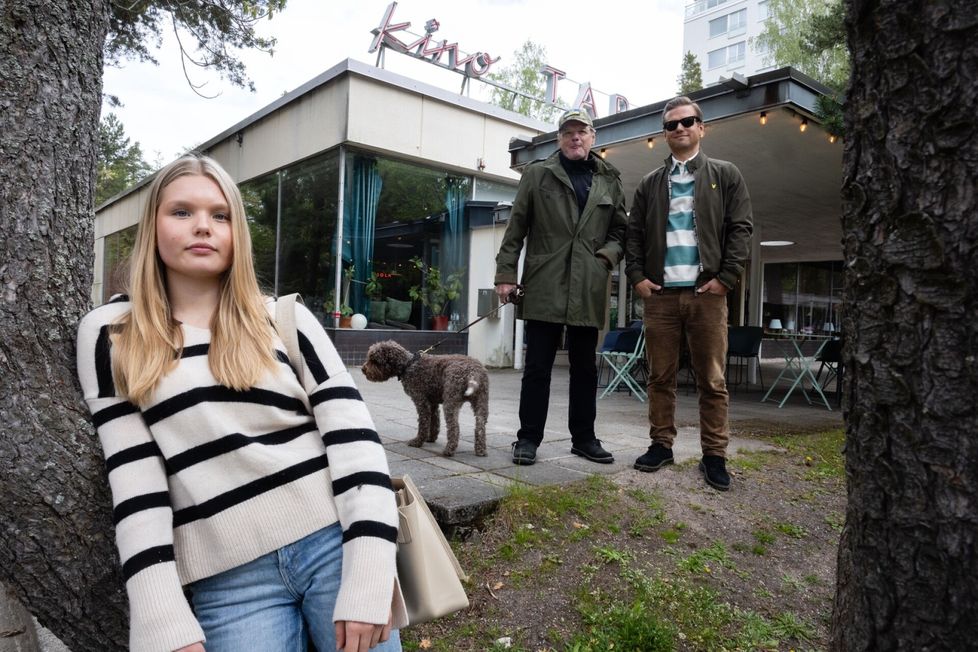 Kino Tapiola on tärkeä paikka Ihamäille. Joulupöydässä perheenjäsenet antavat toisilleen lahjaksi lippuja naapuruston omaan elokuvateatteriin. Kuvassa ovat Kerttu Niemelä, Olli Ihamäki, Ilkka Ihamäki ja Eve-koira.
