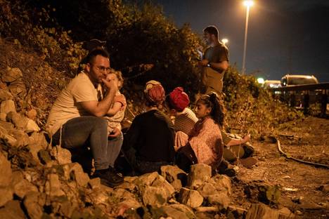 People take cover during a missile strike on the side of a road in Tel Aviv on Tuesday evening.