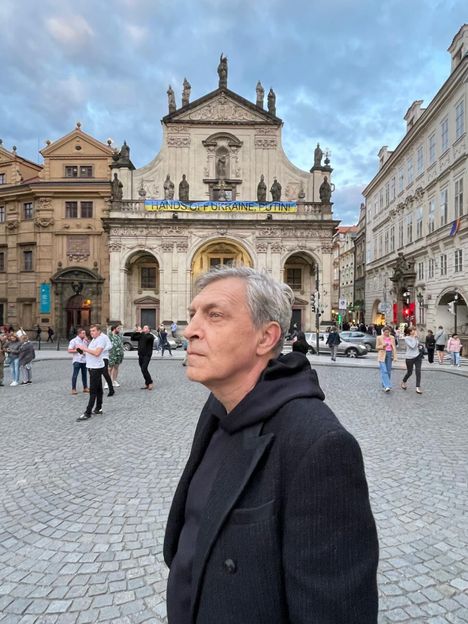 Александр Невзоров позирует на фоне плаката: "Руки прочь от Украины,  Путин!" 