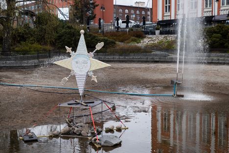 Vesi suihkuaa tähtikasvojen suusta molemmilta puolilta veistosta.