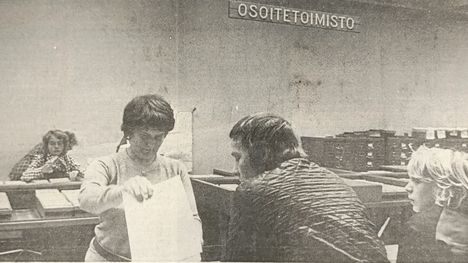 Kiireisimpinä aikoina saattavat hermot olla tiukoilla pöydän kummallakin puolella, myöntää vahtimestari Marjo Palovainio selatessaan asiakkaan kysymää tietoa. Tässä tapauksessa asiasta sentään selvitään sovussa. Uutinen julkaistu Aamulehdessä 19.11.1975.